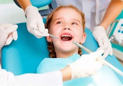 niña curandose los dientes en el odontopediatra